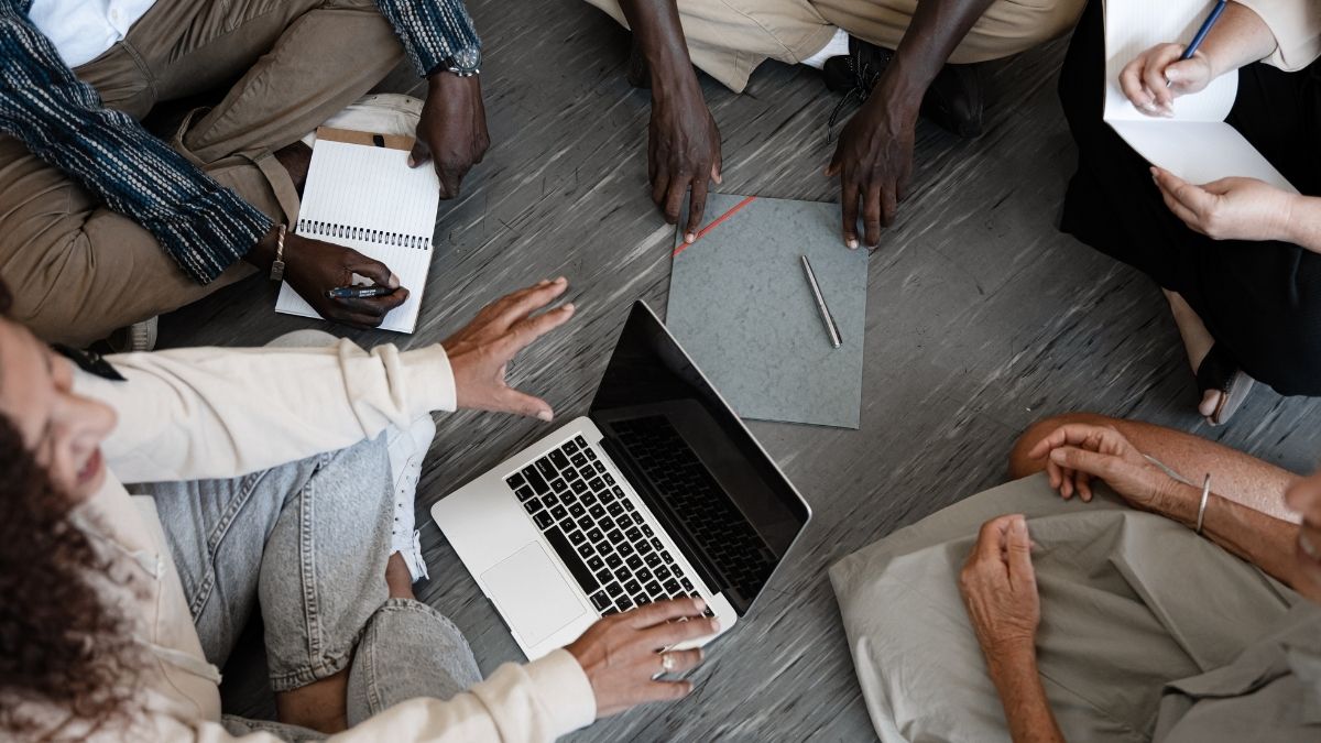 床に座る多国籍グループのミーティング