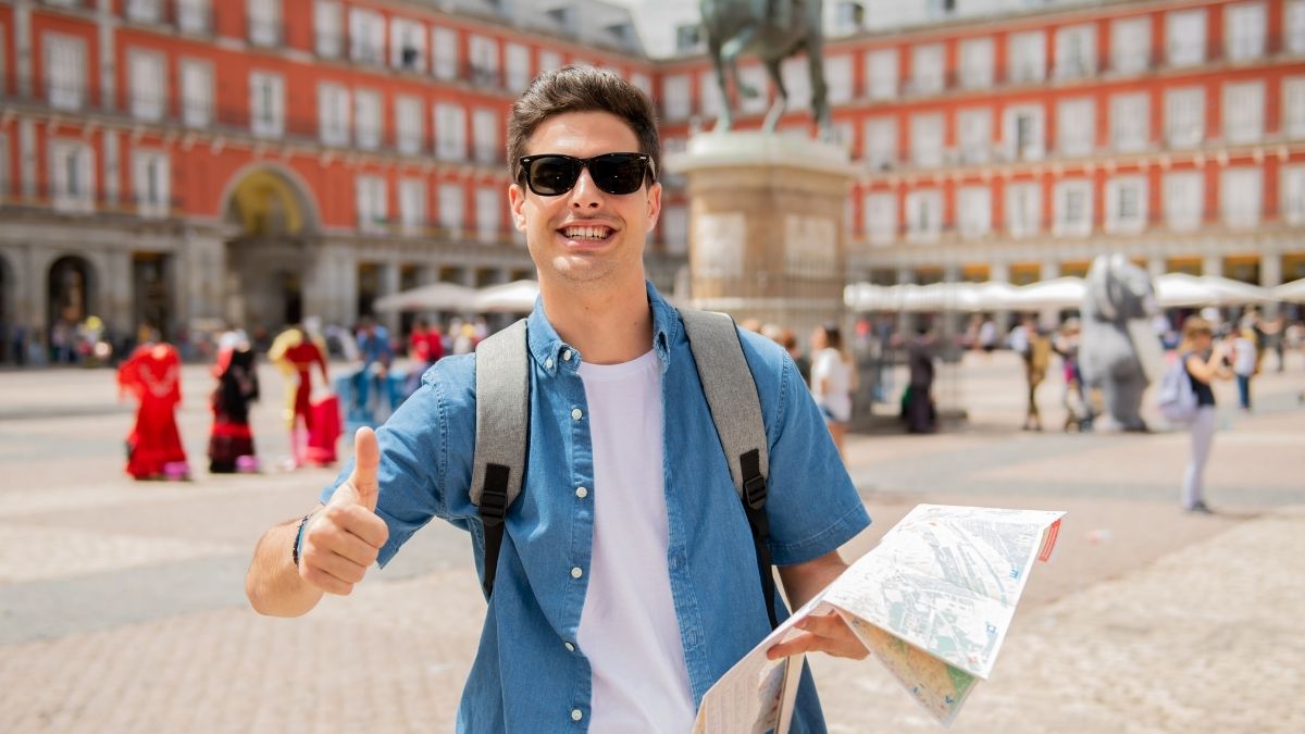 ヨーロッパの広場でサムズアップする旅行者