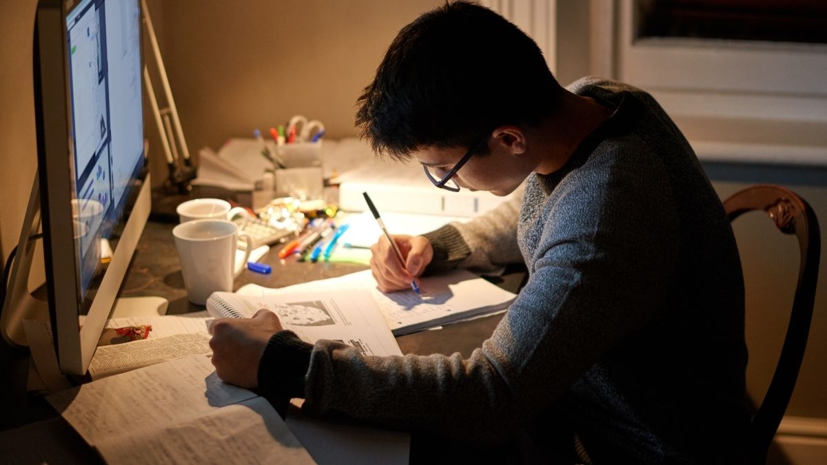 夜遅くにPCで勉強する男性