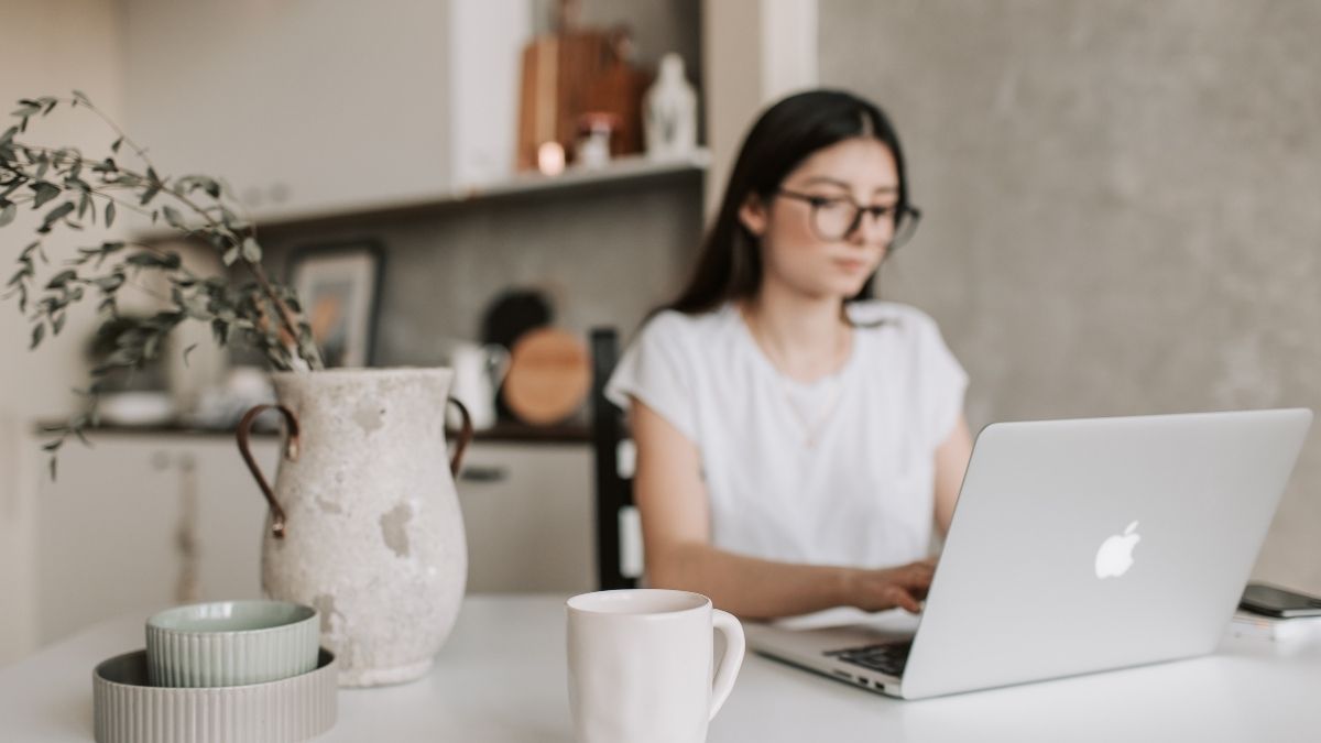 メガネをかけてMacBookで作業する女性